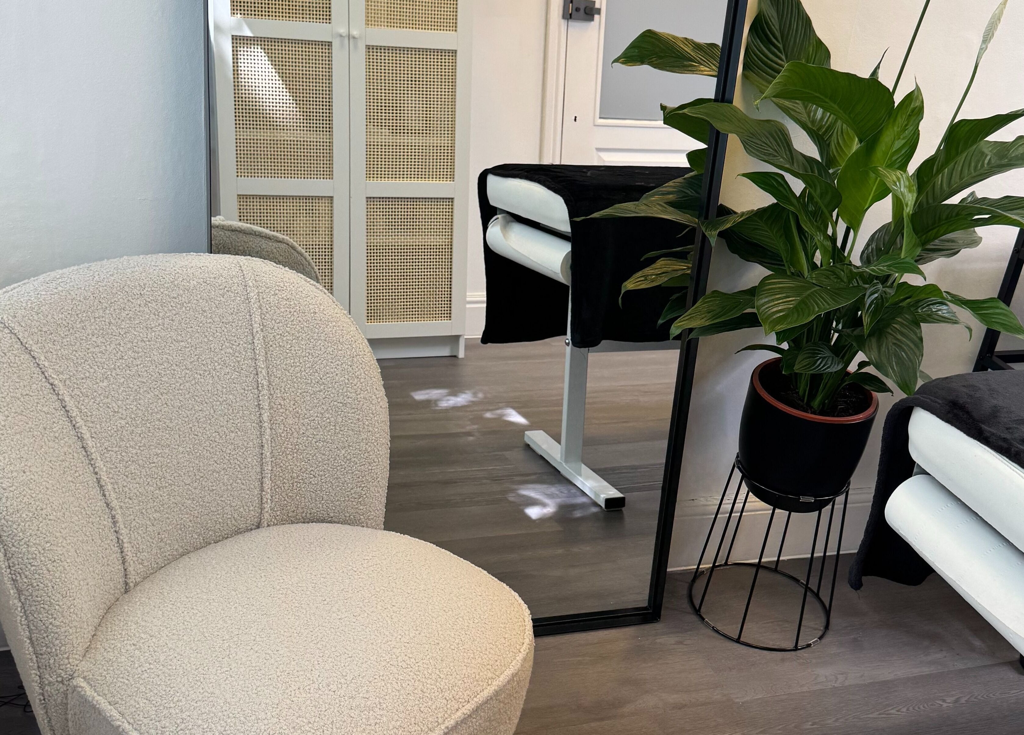 Elegant treatment room at Defined by Linda in Bristol, England, GB with plush chair and lush plant.