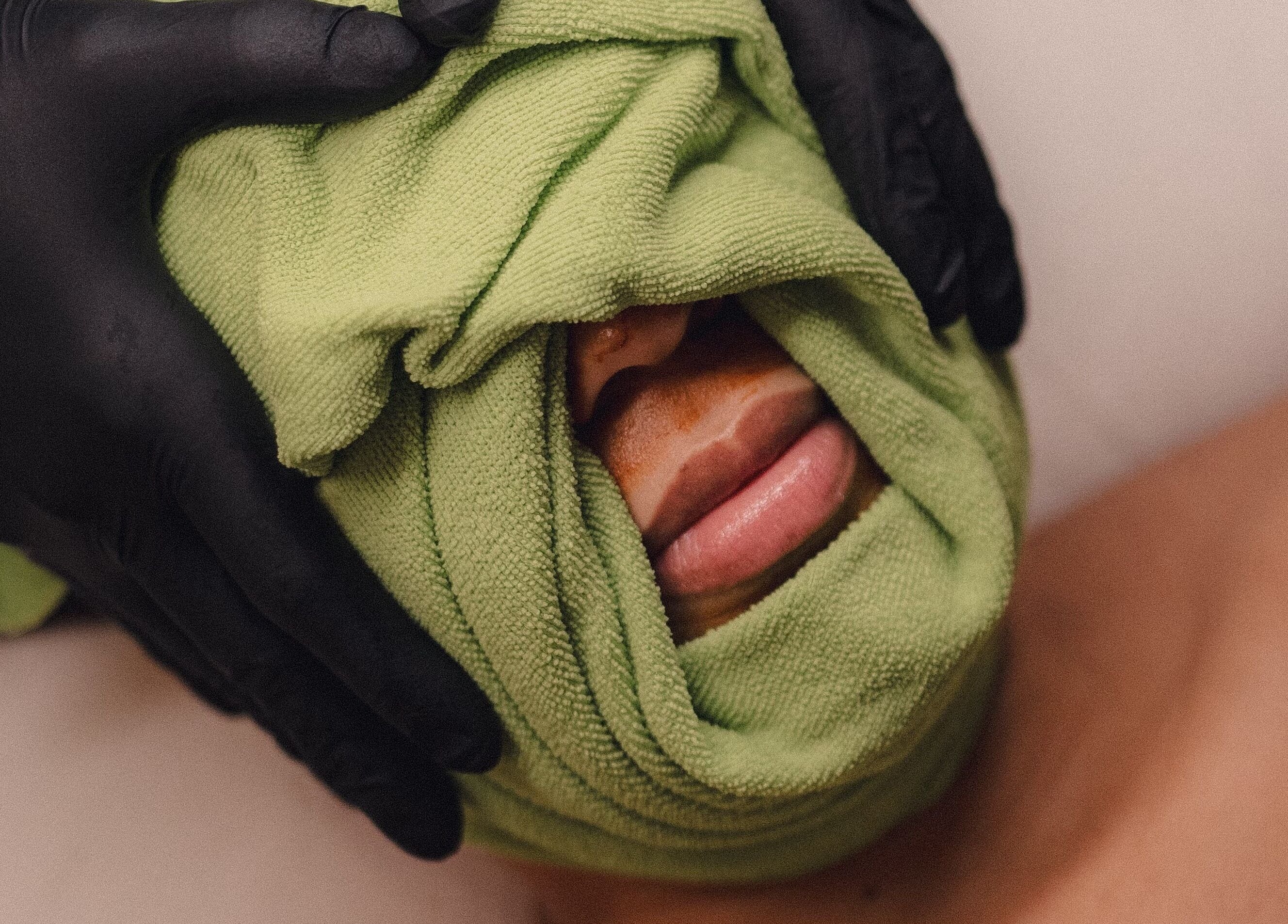 Facial treatment at Skinmethods, West Warwick, Rhode Island, US with green towel wrap enhancing skin rejuvenation.