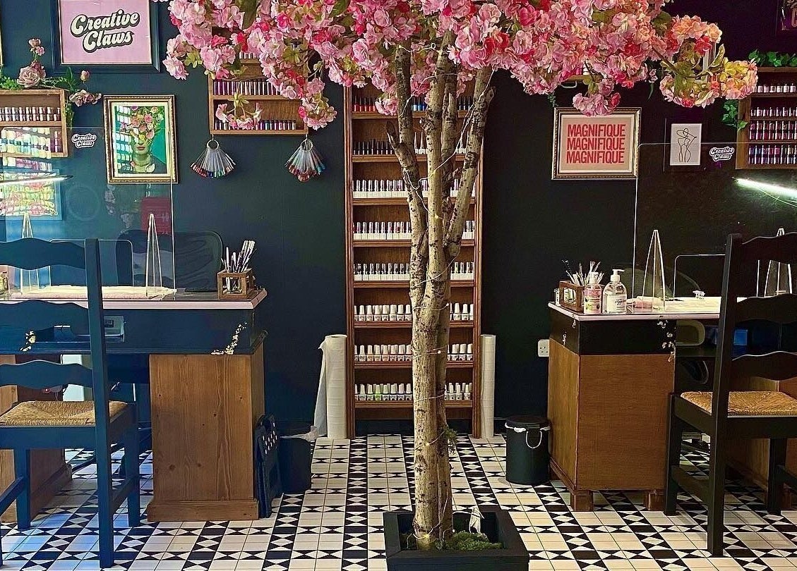 Creative Claws Salon and Training Academy in Holyhead, Wales, GB with elegant nail stations and cherry blossom décor.