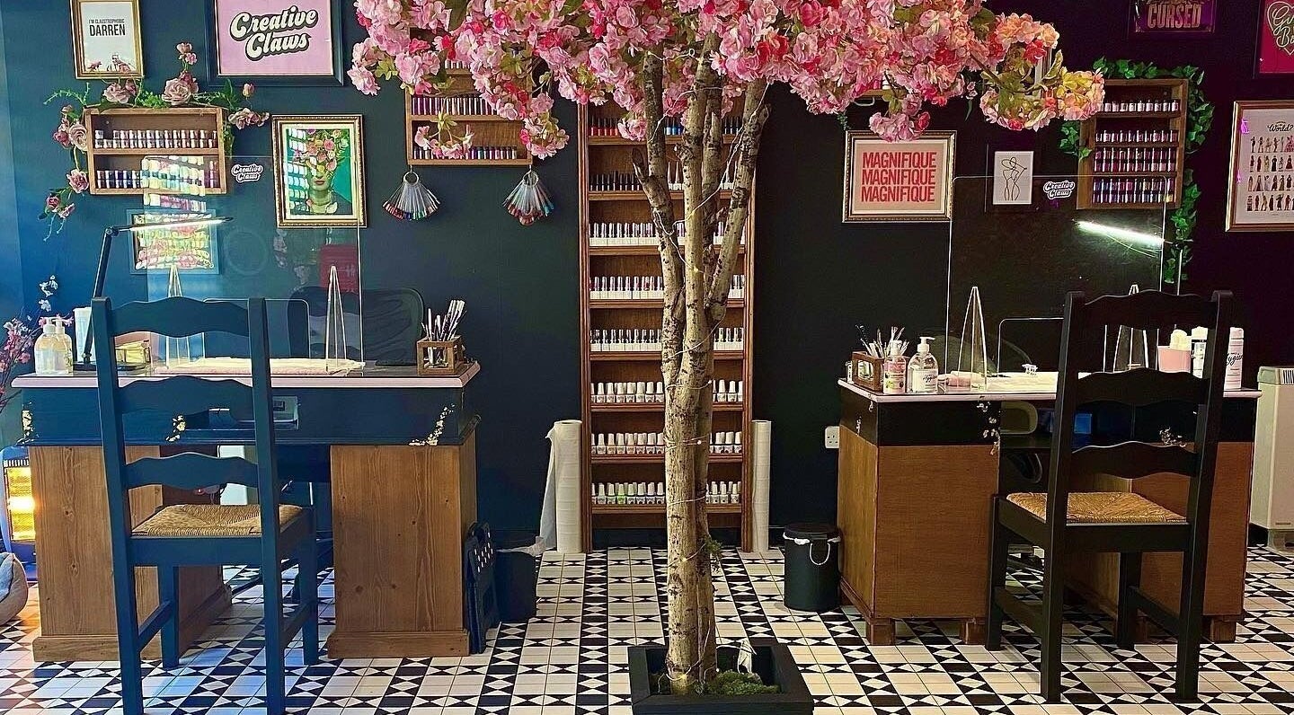 Creative Claws Salon and Training Academy in Holyhead, Wales, GB with elegant nail stations and cherry blossom décor.