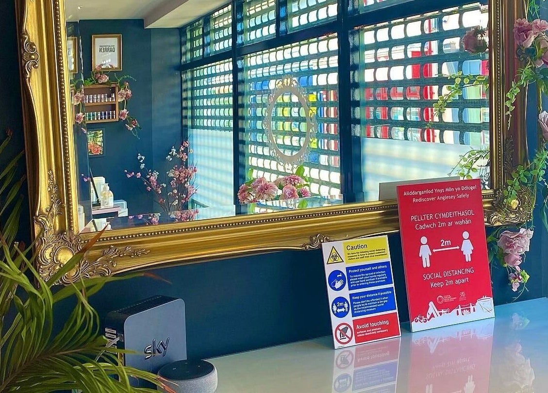 Elegant mirror at Creative Claws Salon and Training Academy, Holyhead, Wales, GB, surrounded by floral decor.