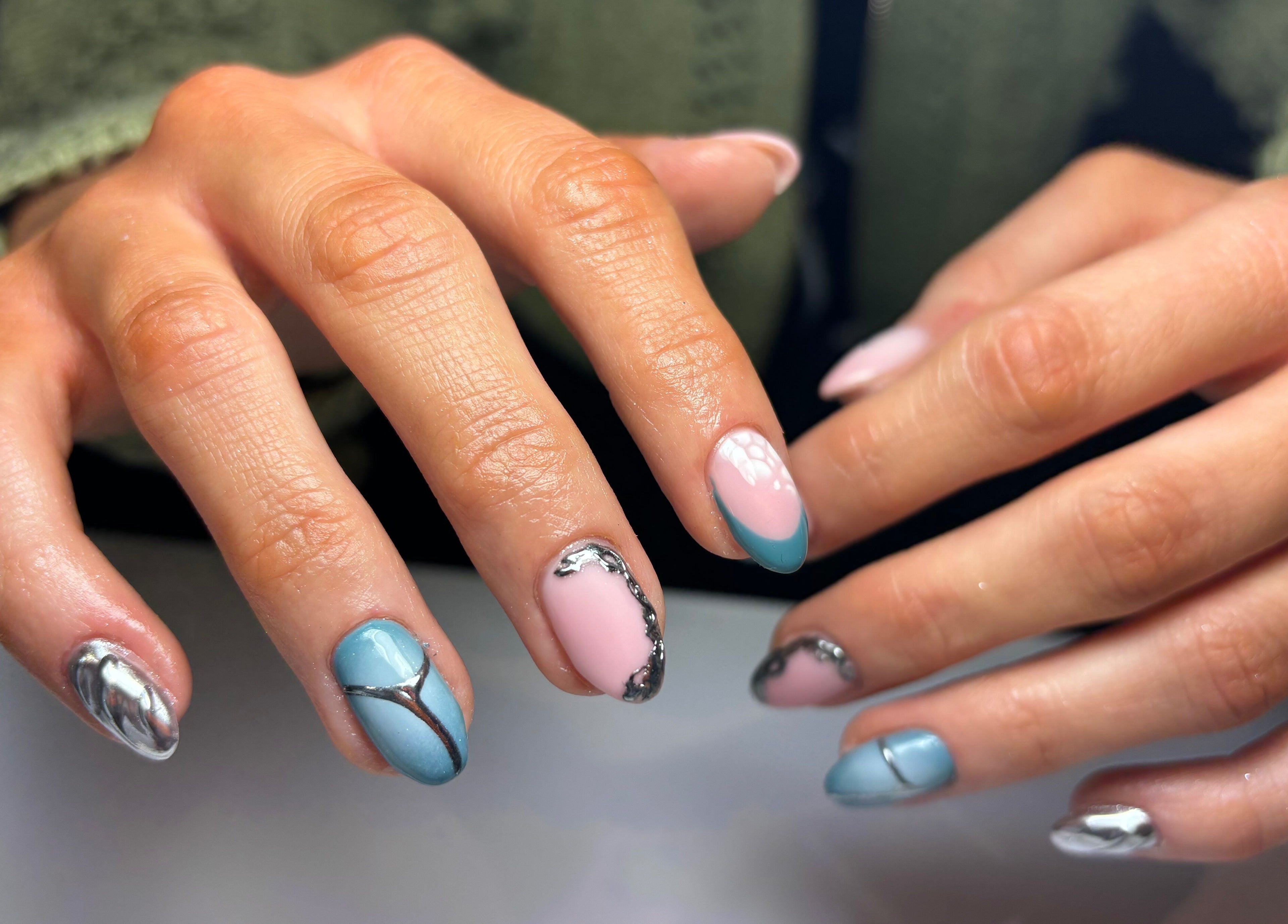 Stylish nail art with pink and blue designs at Creative Claws Salon and Training Academy, Holyhead, Wales, GB.