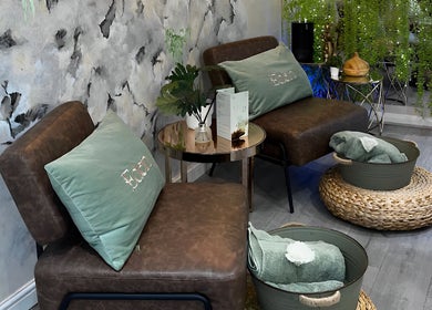 Cozy seating area at Eden Salon, Tyldesley, England, with plush cushions and calming decor.
