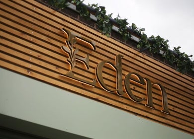 Eden Salon entrance with wooden paneling and greenery in Tyldesley, England, GB.