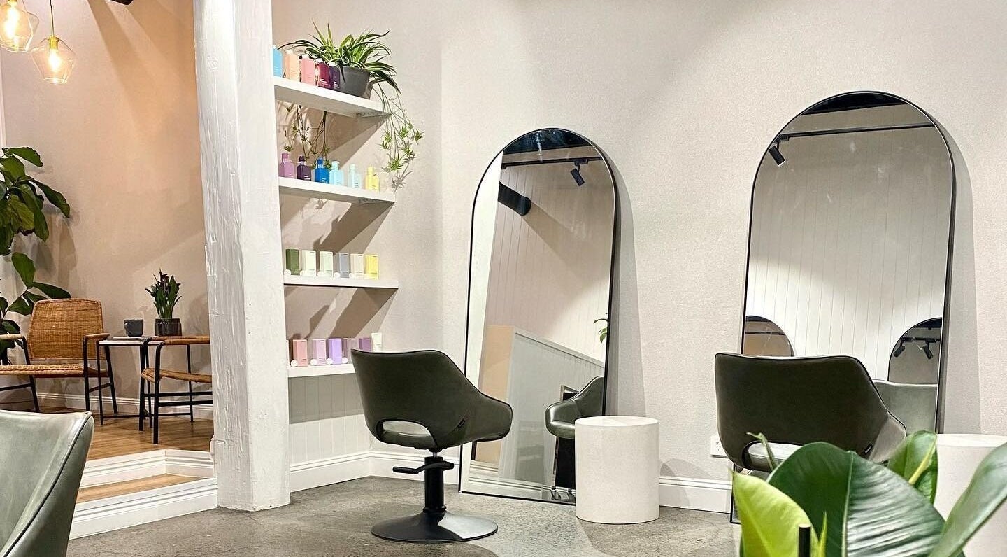 Elegant styling area at Alfie Hair Design in Teneriffe, Queensland, AU with mirrors and modern chairs.