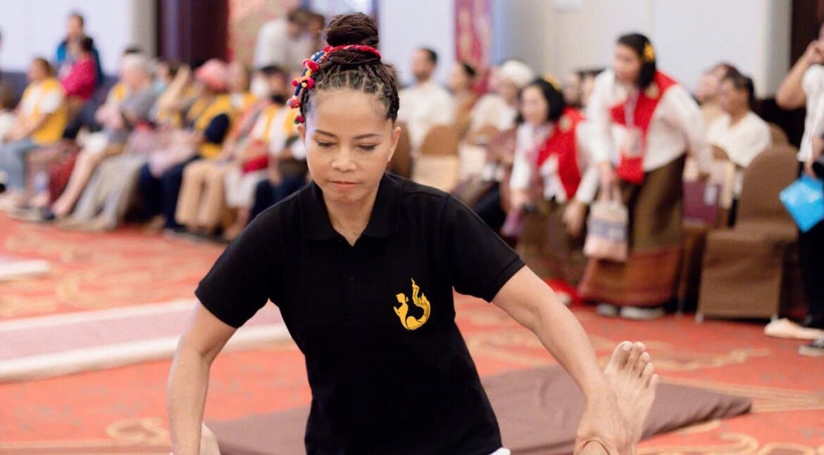 Therapist at Massage by Sommai in Dewsbury, England, GB, carefully performing a massage in a vibrant setting.