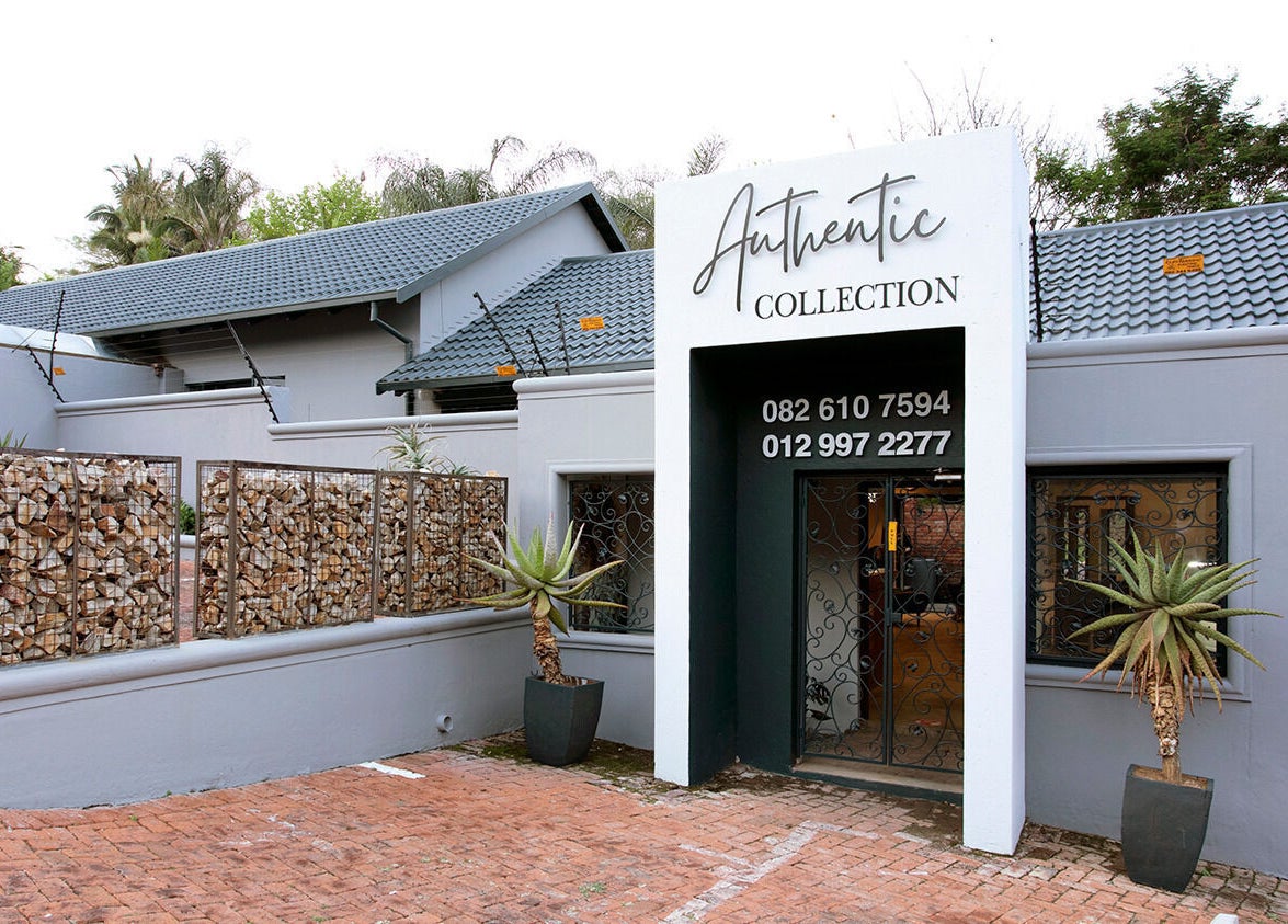 Entrance of Authentic Collection in Pretoria, Gauteng, ZA, showcasing modern aesthetics with lush greenery.