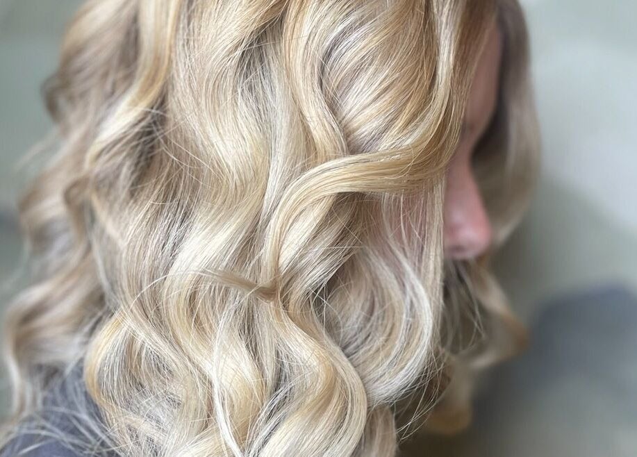 Elegant blonde curls styled at The Salon, Marchwiel, Wales, GB, showcasing vibrant hair artistry.