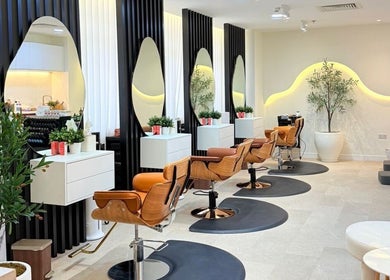 Chic interior of Off White Salon & Spa in Abu Dhabi, Abu Dhabi, AE showcasing stylish salon chairs and mirrors.