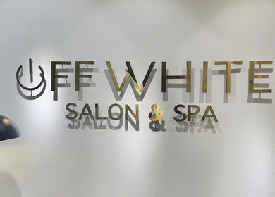 Elegant logo of Off White Salon & Spa in Abu Dhabi, AE on a calming, light wall surface.