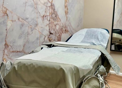 A cozy treatment room at Shape Zone London, located in London, England, GB, with a stylish marble wall.