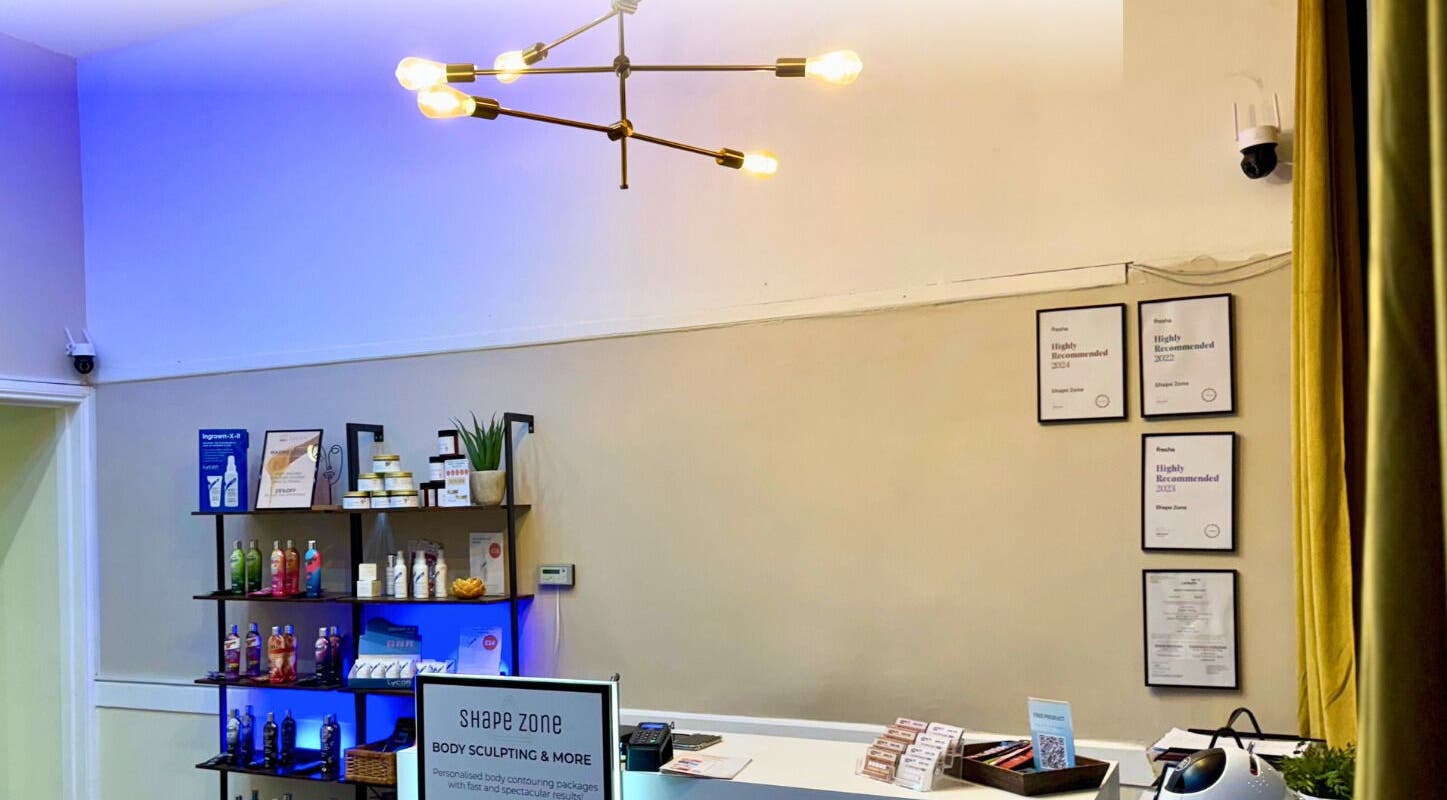 Reception area of Shape Zone London in London, England, GB with stylish lighting and displayed beauty products.