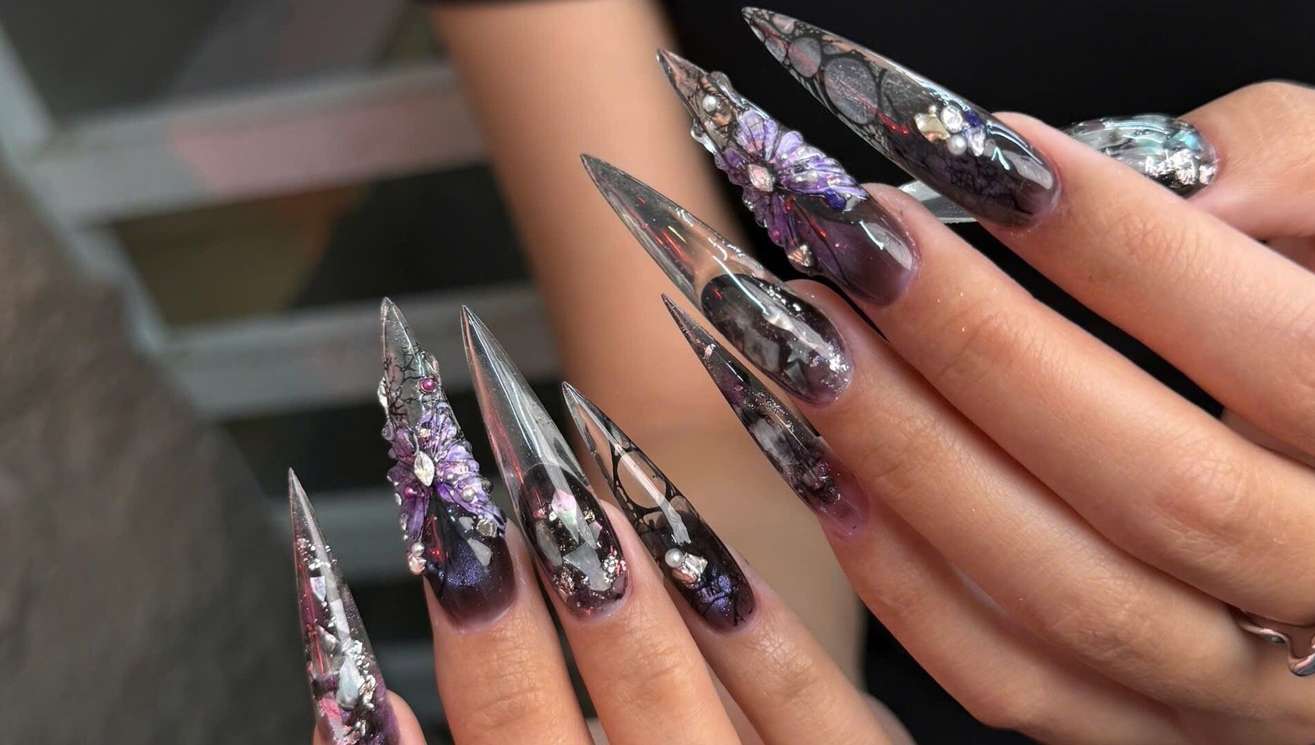 Intricate nail art at Iconic Nails Studio, Los Altos, California, US, showcasing detailed purple 3D designs.