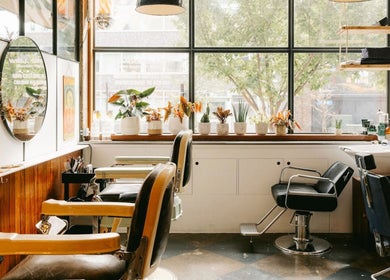 Bright salon interior at Lume Hair Studio | Netil Lane, London, England, GB with stylish chairs and plants.