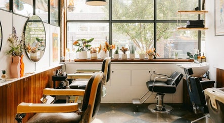 Bright salon interior at Lume Hair Studio | Netil Lane, London, England, GB with stylish chairs and plants.