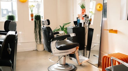 Modern black barber chair in Lume Hair Studio at Netil Lane, London, England, GB with sleek mirror and plants.
