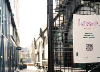 Entrance view of Lume Hair Studio | Netil Lane in London, England, GB with modern signage and urban surroundings.
