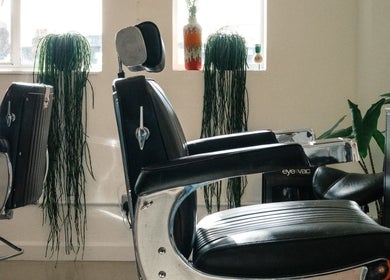 Elegant barber chairs at Lume Hair Studio | Netil Lane, London, England, GB. Natural light and greenery enhance the space.