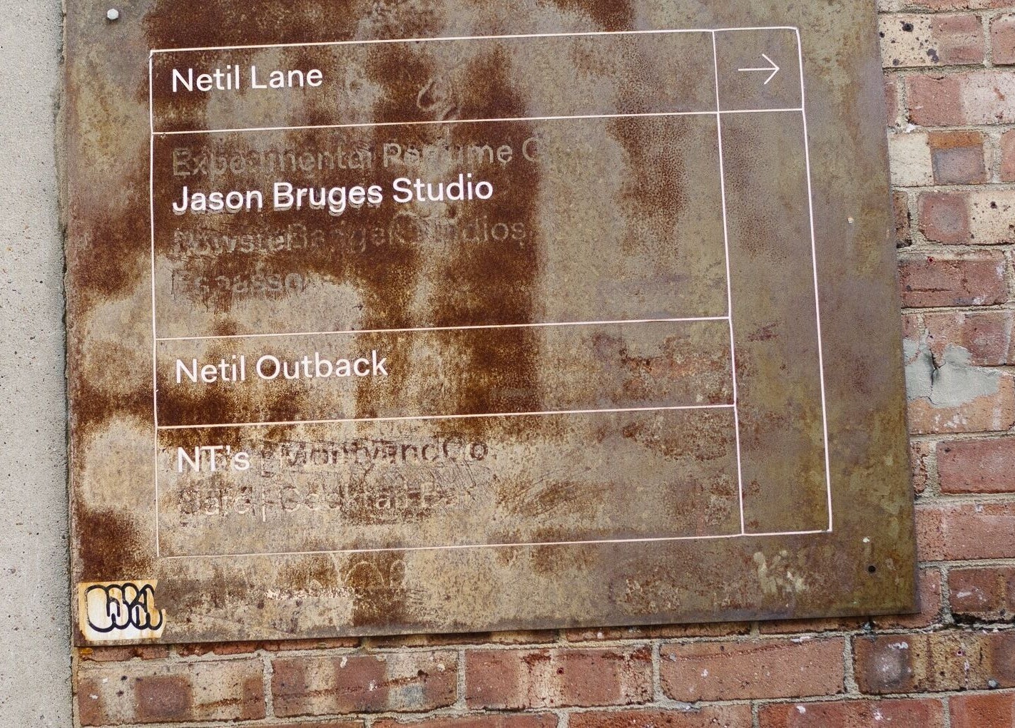 Rustic sign on brick wall near Lume Hair Studio | Netil Lane, London, England, GB.