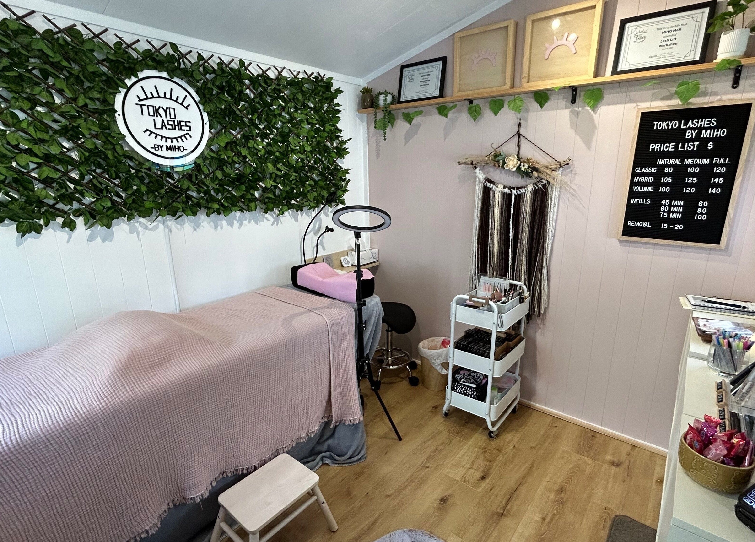 Cozy interior of The Lash Hub in Auckland, NZ, featuring a treatment bed, lush decor, and beauty products.