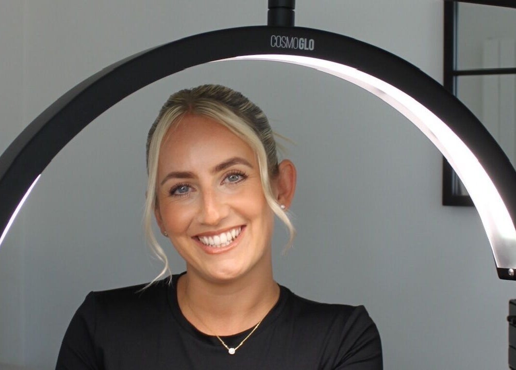Smiling woman under salon lighting at Just Do Fab, Brighton And Hove, England, GB.