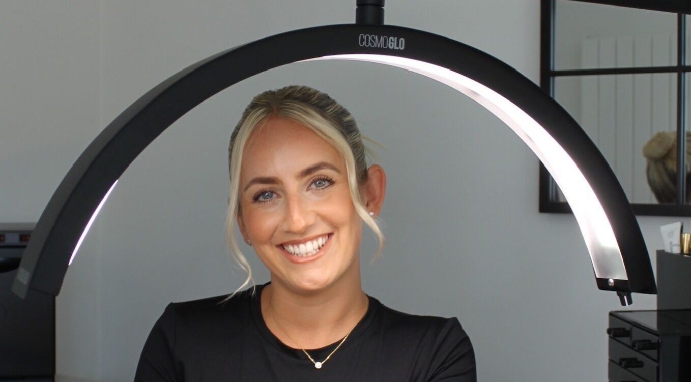 Smiling woman under salon lighting at Just Do Fab, Brighton And Hove, England, GB.
