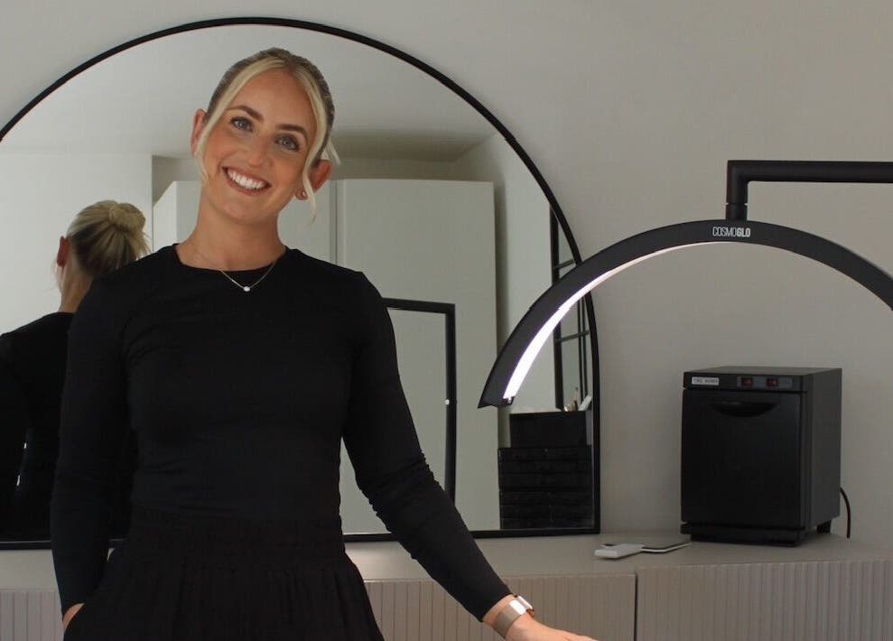 Smiling individual at 'Just Do Fab', Brighton And Hove, England, GB, with stylish mirror backdrop.