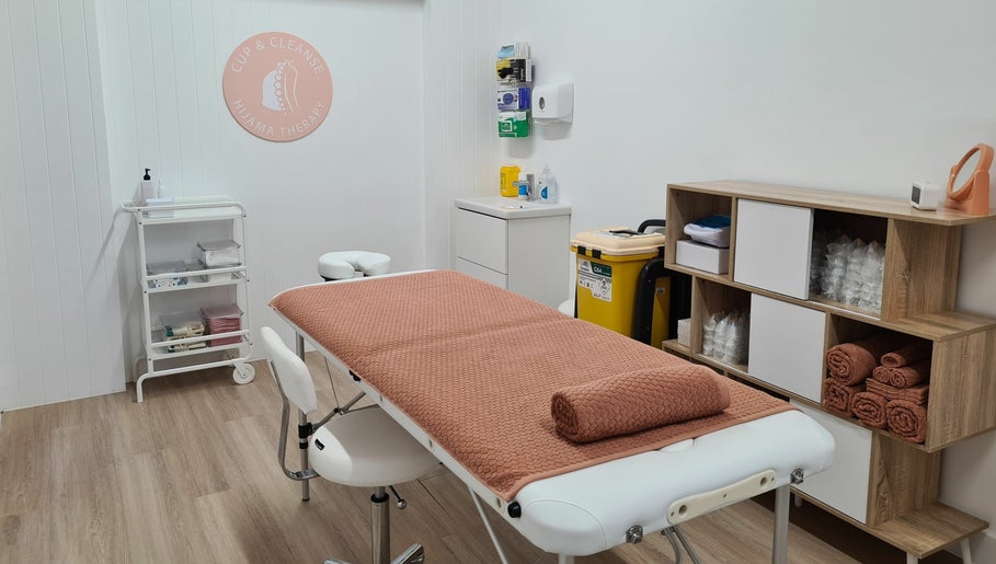 Cup & Cleanse treatment room at Runaway Bay, Queensland, AU with massage table and warm decor.