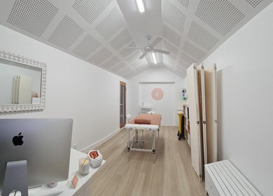 Peaceful spa room at Cup & Cleanse, Runaway Bay, QLD, AU. Features a massage table, stylish decor, and soothing ambiance.