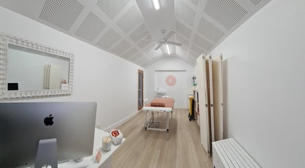 Peaceful spa room at Cup & Cleanse, Runaway Bay, QLD, AU. Features a massage table, stylish decor, and soothing ambiance.