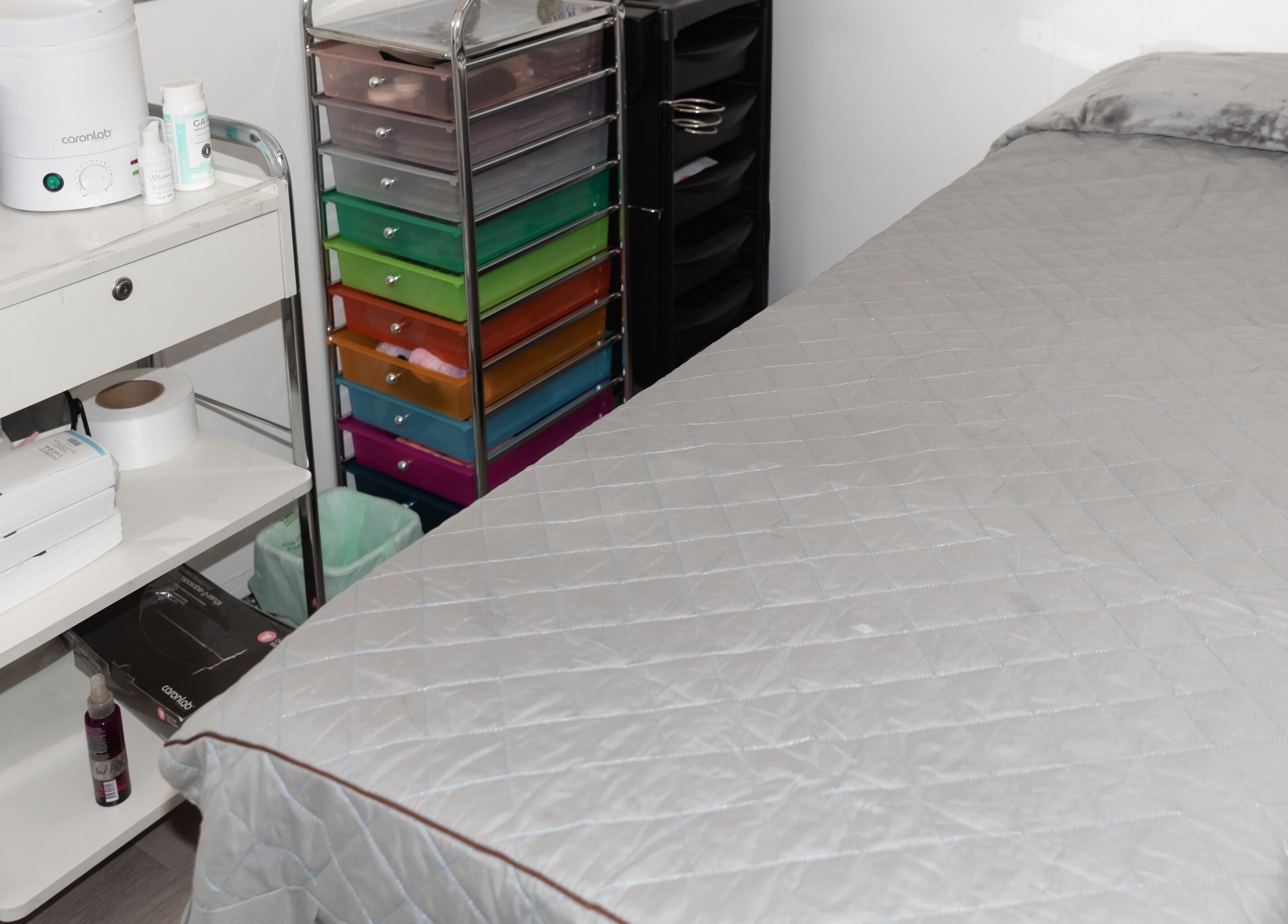 Spa room at Adore Makeovers in Newton, South Australia, AU featuring a comfy treatment bed and organized shelves.