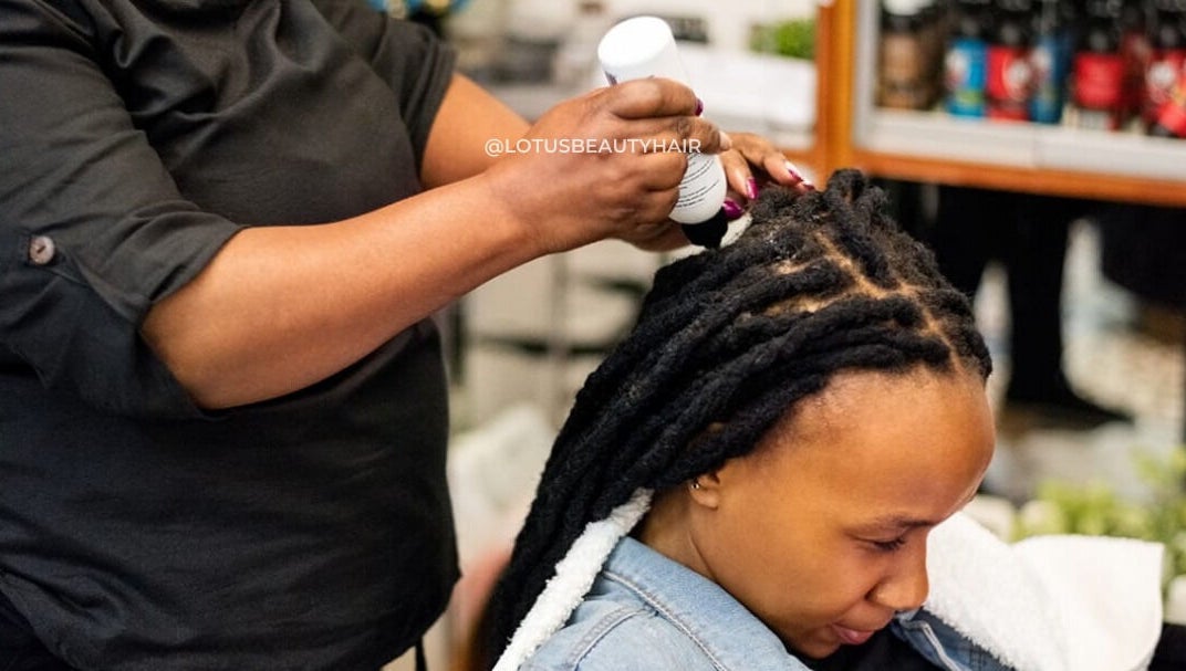 Hair care service at Lotus Beauty Hair in Cape Town, Western Cape, ZA. A stylist applies treatment to a client's locks.