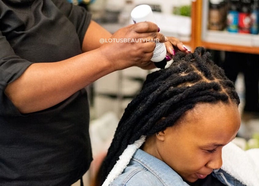 Hair care service at Lotus Beauty Hair in Cape Town, Western Cape, ZA. A stylist applies treatment to a client's locks.