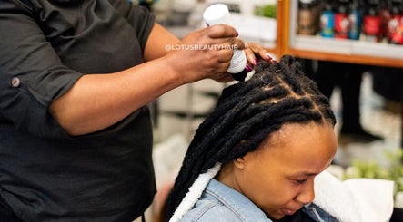 Hair care service at Lotus Beauty Hair in Cape Town, Western Cape, ZA. A stylist applies treatment to a client's locks.