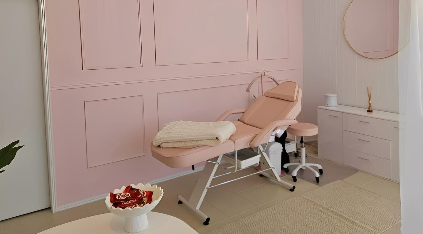 Elegant treatment room at The Lash Hub, Bundaberg South, Queensland, AU with a pink chair and minimalist decor.