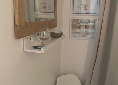 Cozy corner at Eva B. Wiebe, CMP in Aylmer, ON, CA, adorned with certificates and a mirror above a shelf.