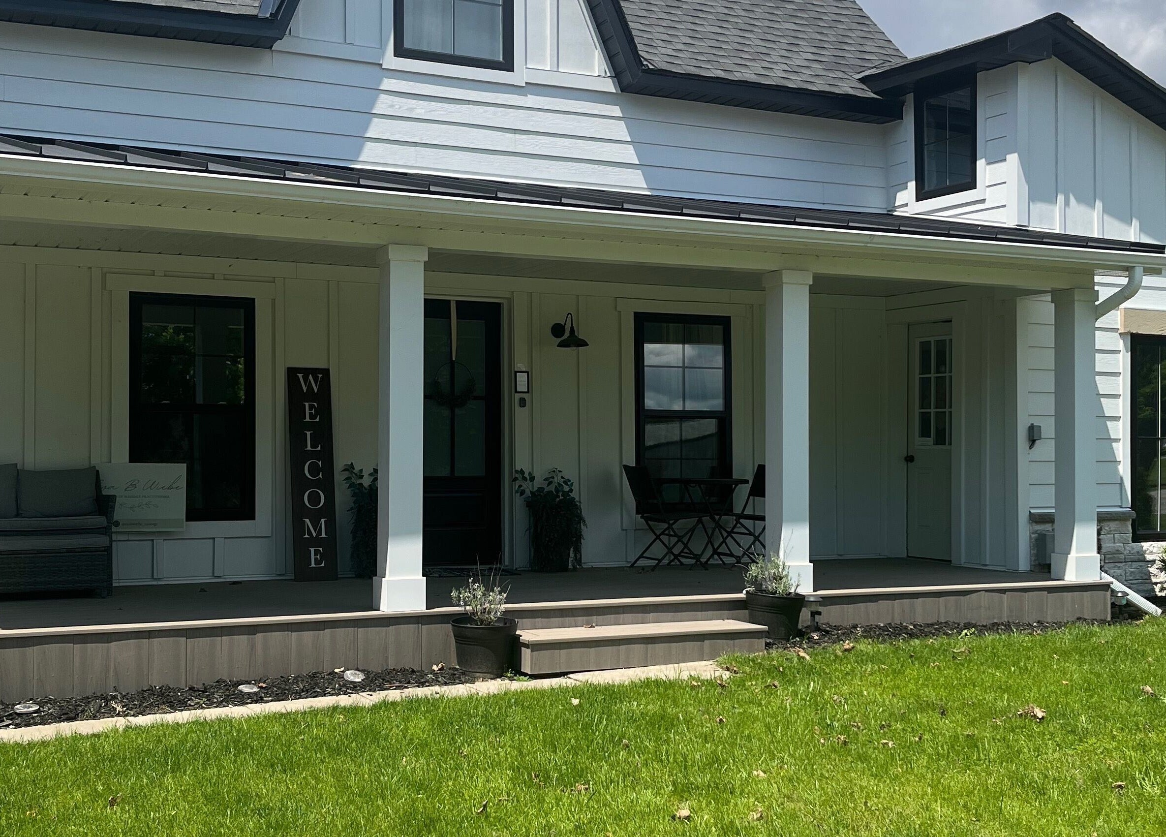Welcoming porch of Eva B. Wiebe, CMP in Aylmer, ON, CA. Features cozy seating and lush greenery.