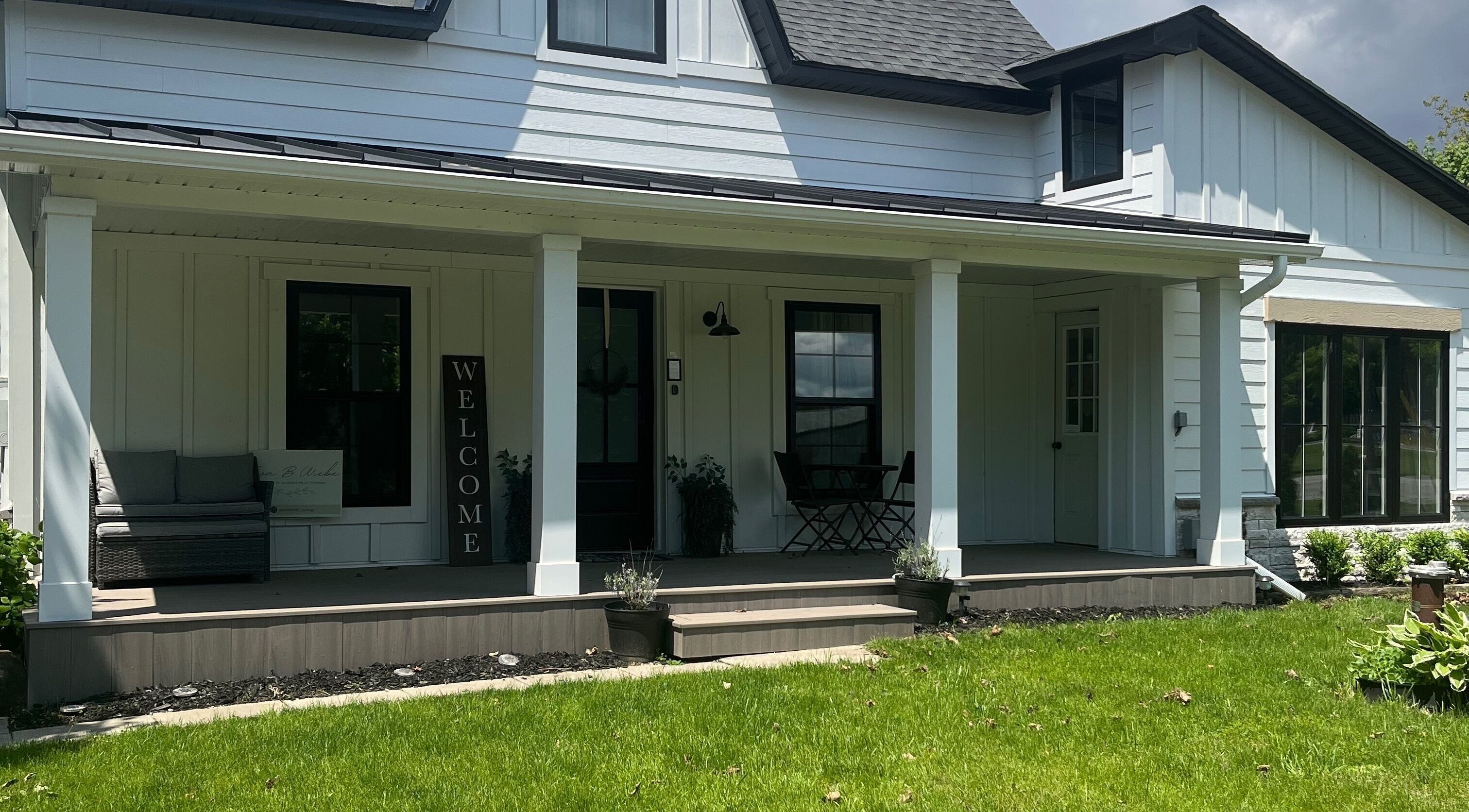 Welcoming porch of Eva B. Wiebe, CMP in Aylmer, ON, CA. Features cozy seating and lush greenery.