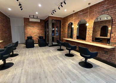 Chic interior of Hair by Coco Milk salon in Melbourne, Victoria, AU with modern styling chairs and mirrors.