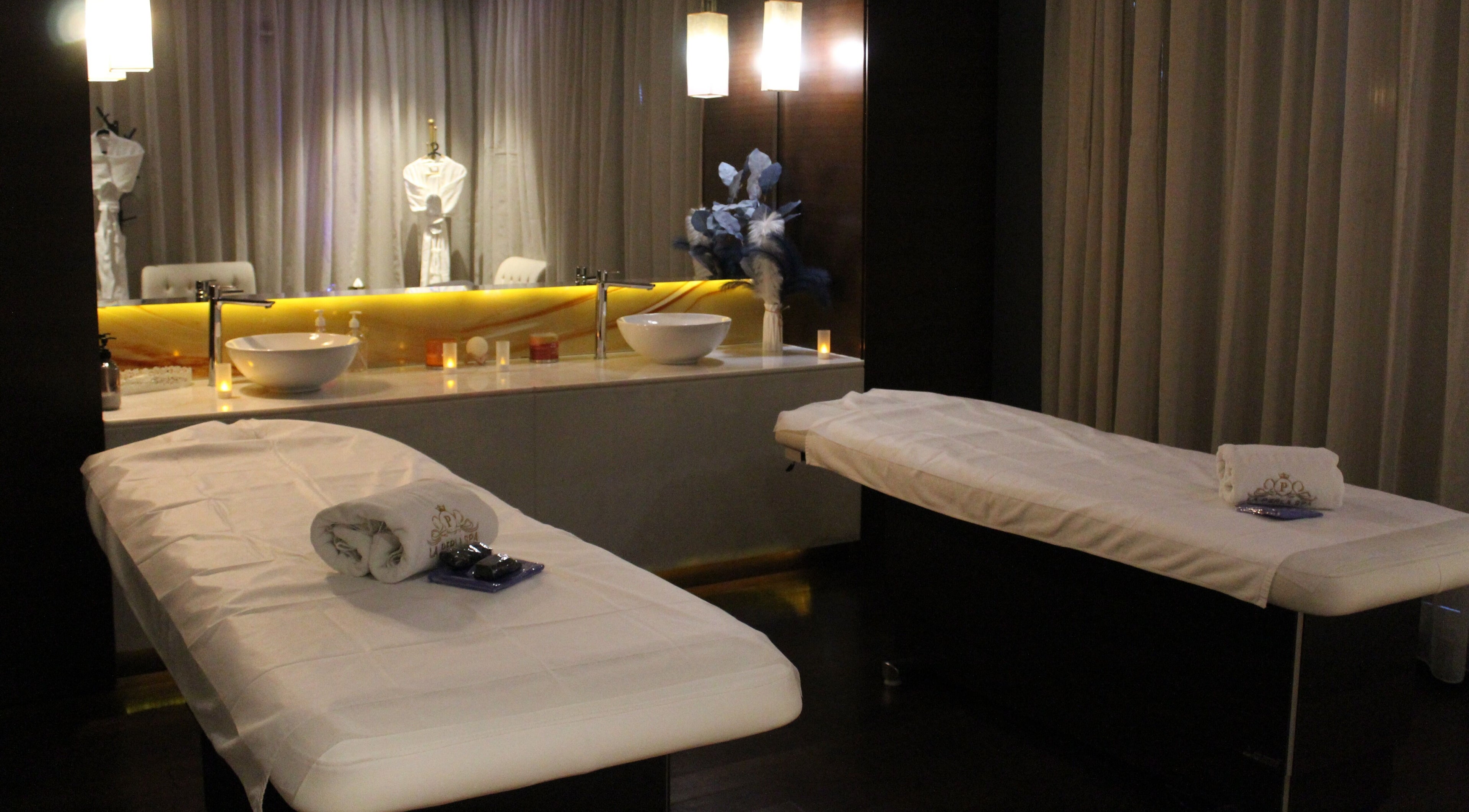Relaxing massage room at La Perla Spa Dubai, Dubai, Dubai, AE with plush tables and ambient lighting.