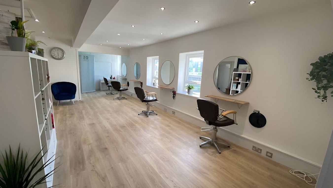 Modern and spacious interior of 20 Twenty Hair Salon in Falmouth, England, GB featuring stylish chairs and mirrors.