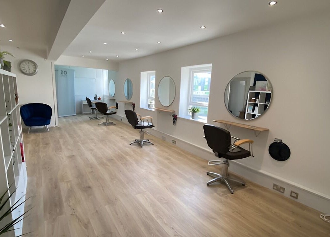 Modern and spacious interior of 20 Twenty Hair Salon in Falmouth, England, GB featuring stylish chairs and mirrors.