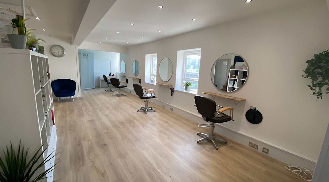 Modern and spacious interior of 20 Twenty Hair Salon in Falmouth, England, GB featuring stylish chairs and mirrors.