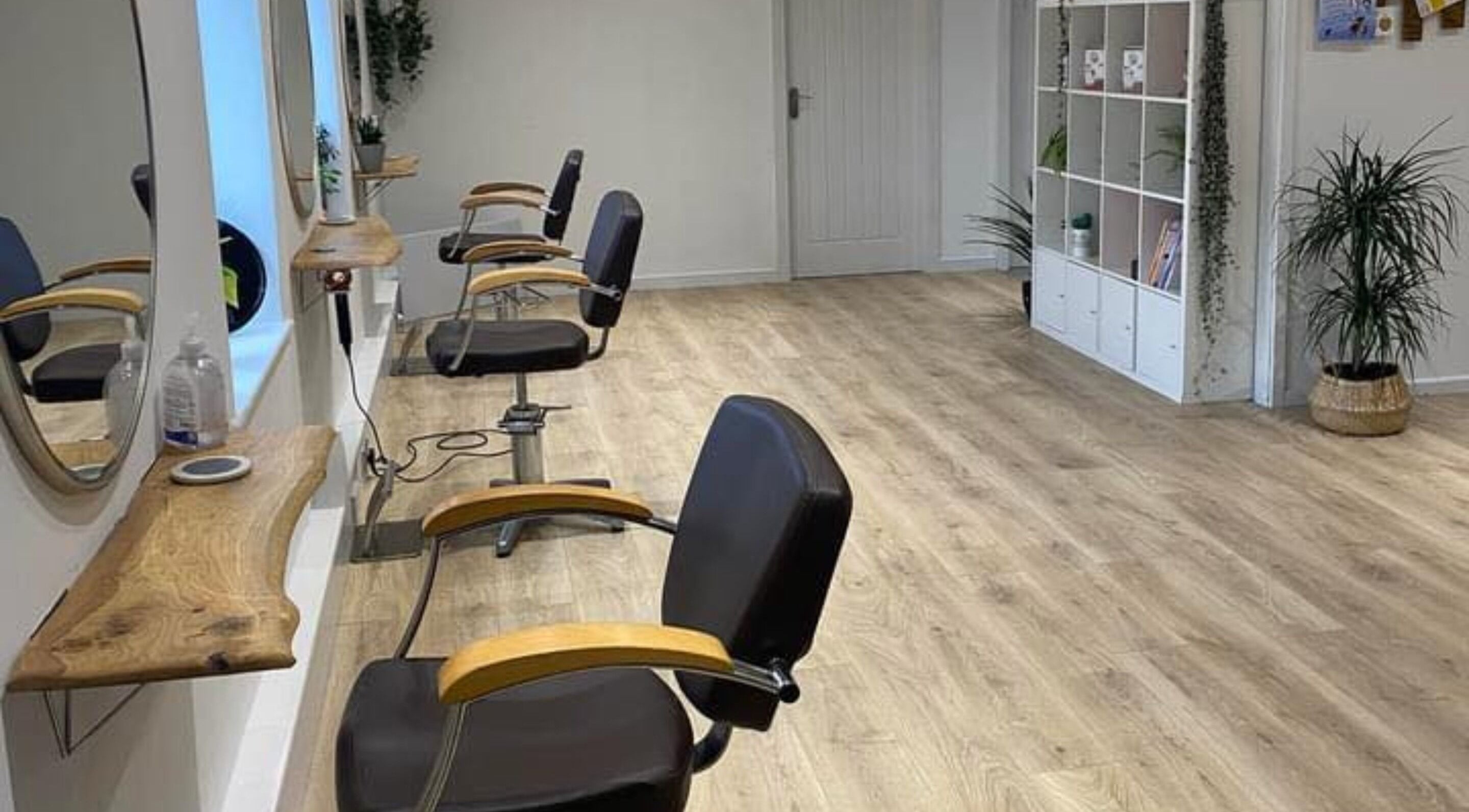 Spacious interior of 20 Twenty Hair Salon in Falmouth, England, GB featuring stylish chairs and modern decor.