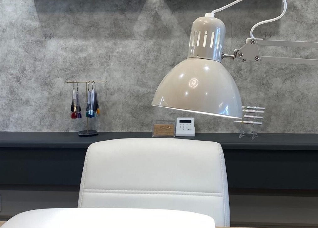 Modern nail station at Nails by Erika in Morley, England, GB with a white chair and lamp.