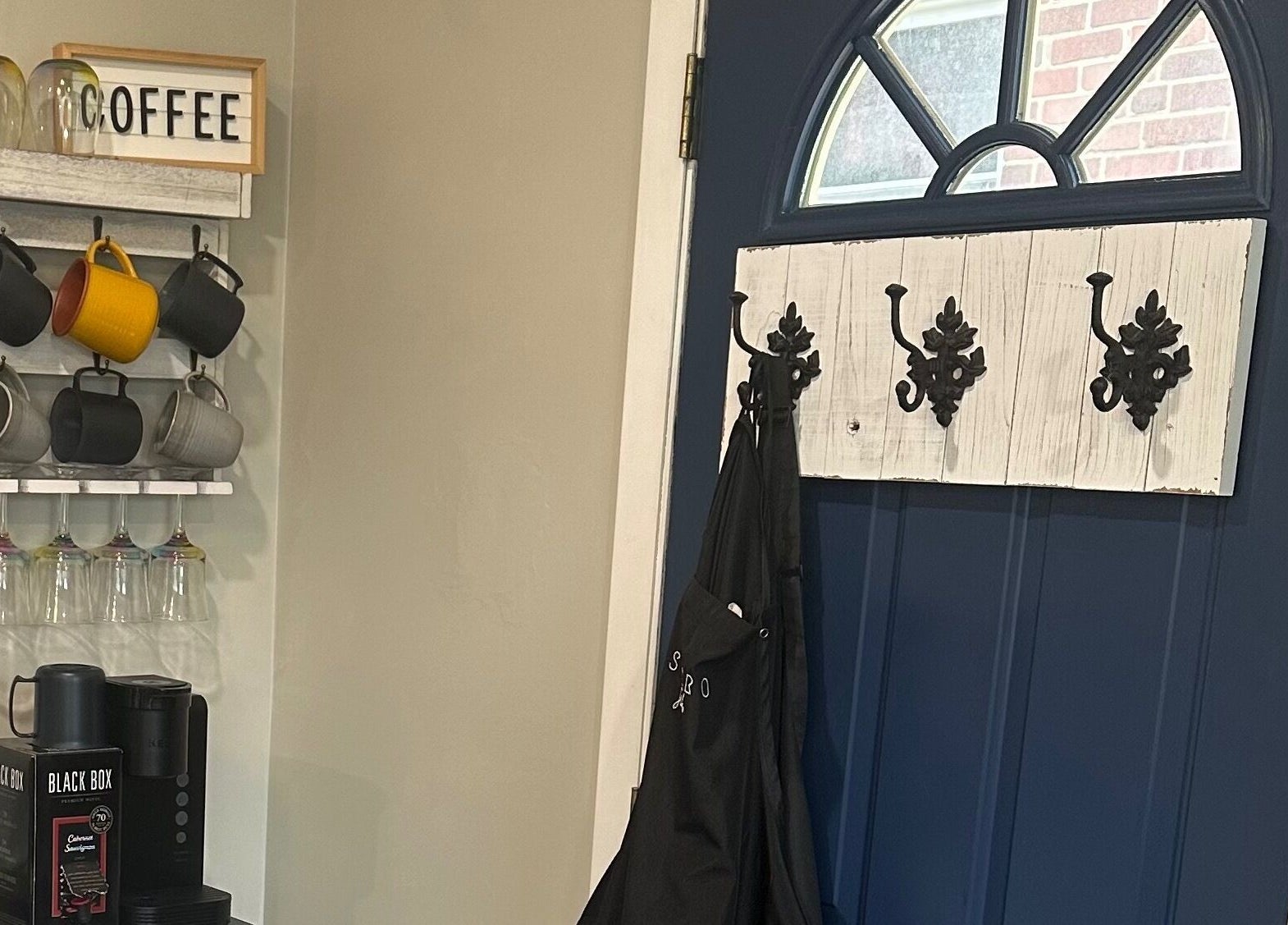 Cozy coffee corner in Sacro Studio, LLC, Bethlehem, Pennsylvania, US with mugs, a coffee machine, and decorative hooks.