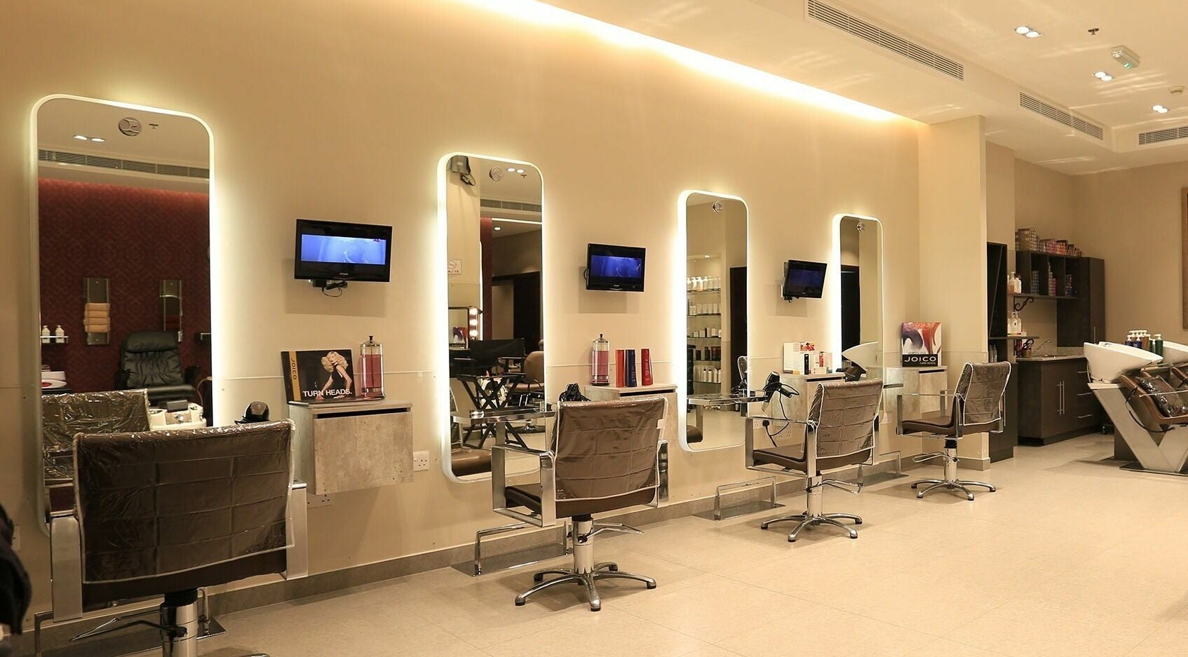 Modern interior of Amaya Salon and Spa in Dubai, AE showcasing elegant styling chairs and mirrored stations.