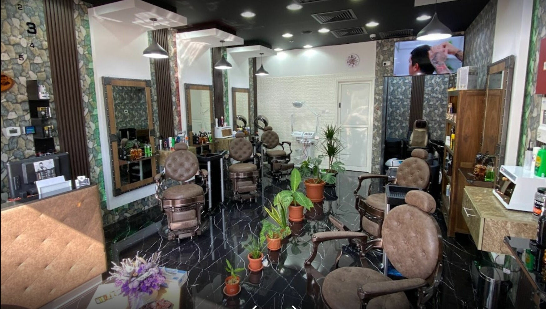 Dimassi Gents Salon interior in Dubai, AE with sleek chairs, modern decor, and plants for a relaxing atmosphere.