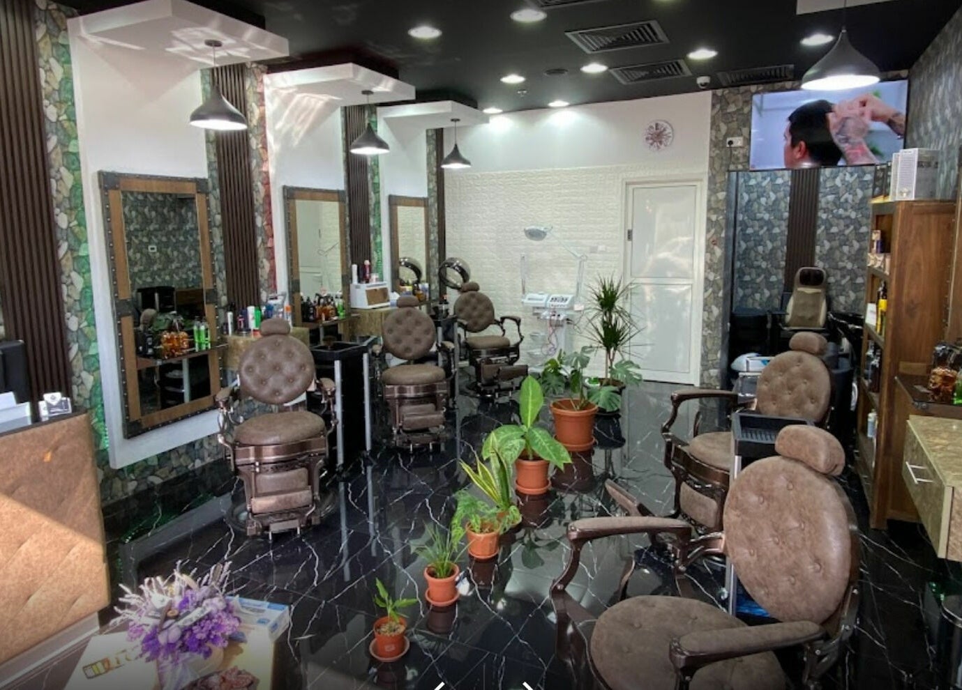 Dimassi Gents Salon interior in Dubai, AE with sleek chairs, modern decor, and plants for a relaxing atmosphere.