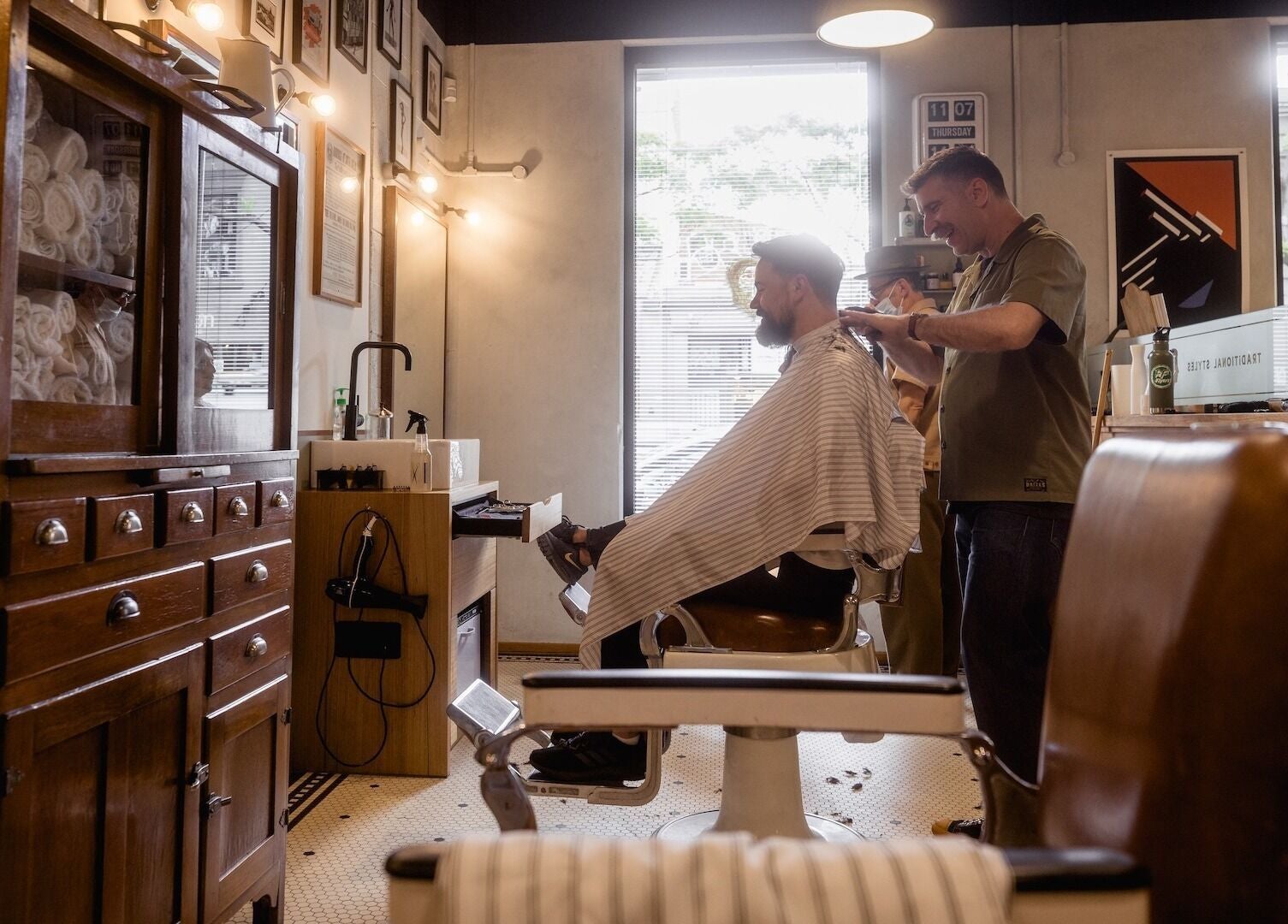A barber styling hair at P&P Barbers — PPHH Store, Melbourne, Victoria, AU in a vintage-themed setting.